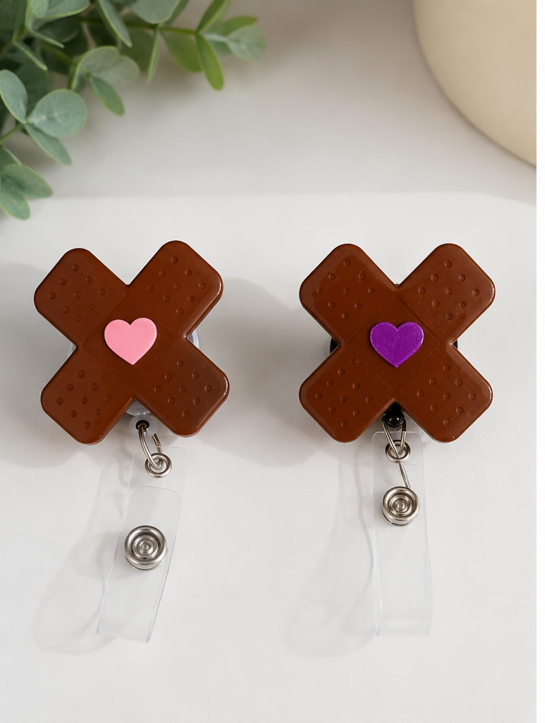 Brown bandages shaped in an “X”badge holders with heart designs on a white background and a person wearing blue scrubs with a registered nurse badge holder.