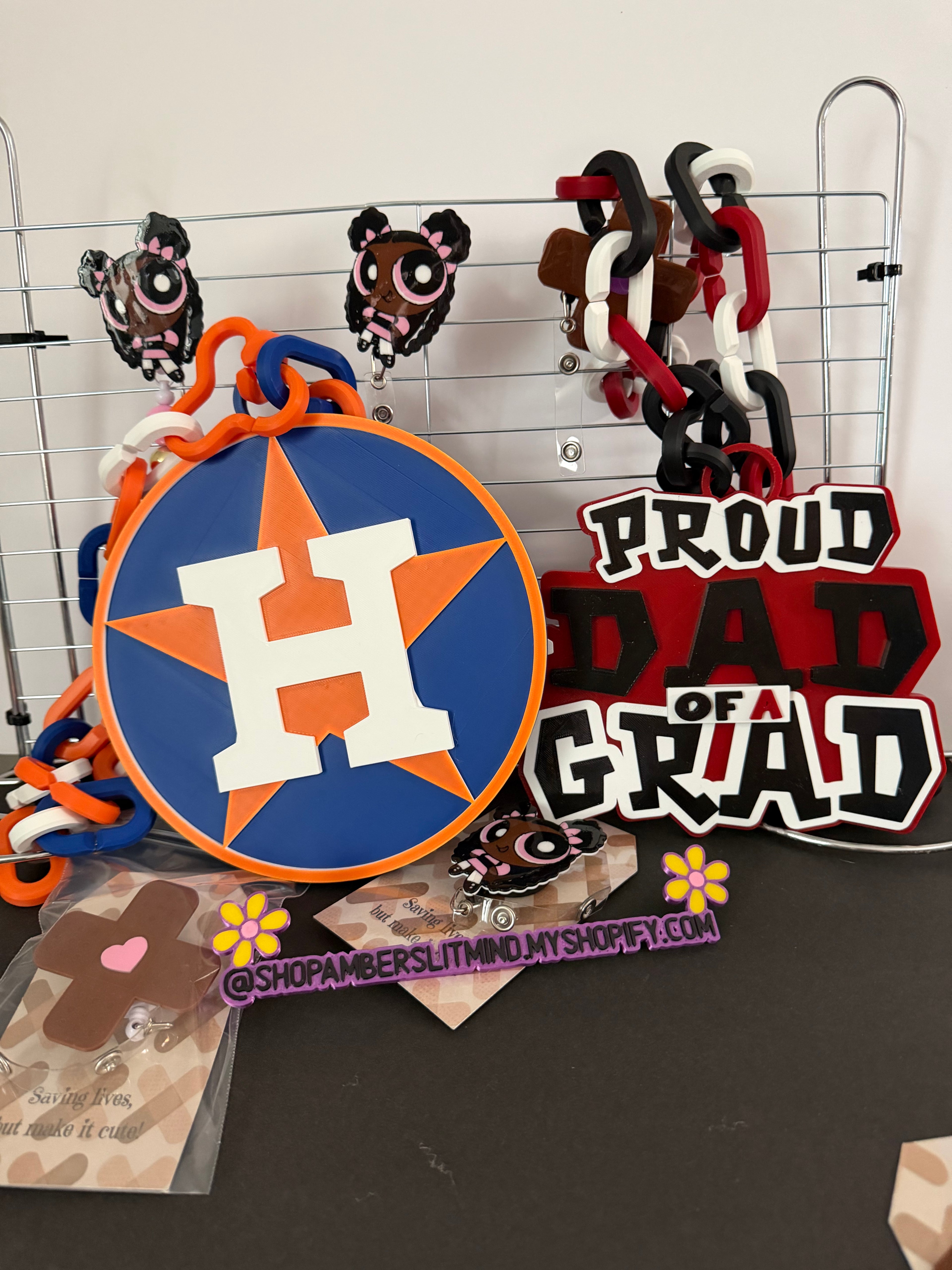Decorative items with a prominent 'H' logo on a wire rack against a black background