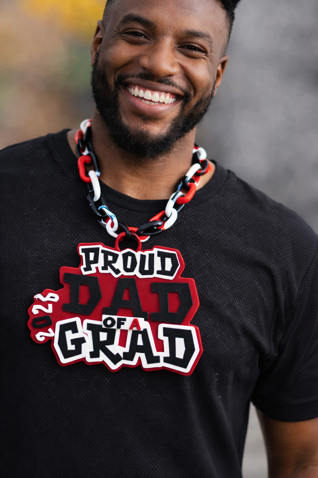 Smiling dad wearing proud dad of a grad hype chain
